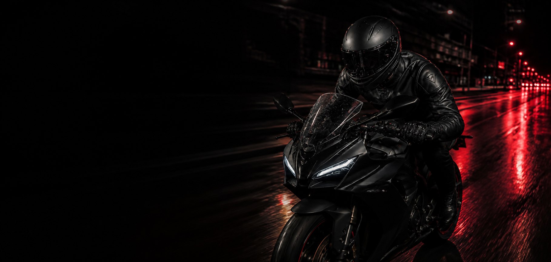Motociclista equipado con casco integral negro en una escena urbana nocturna